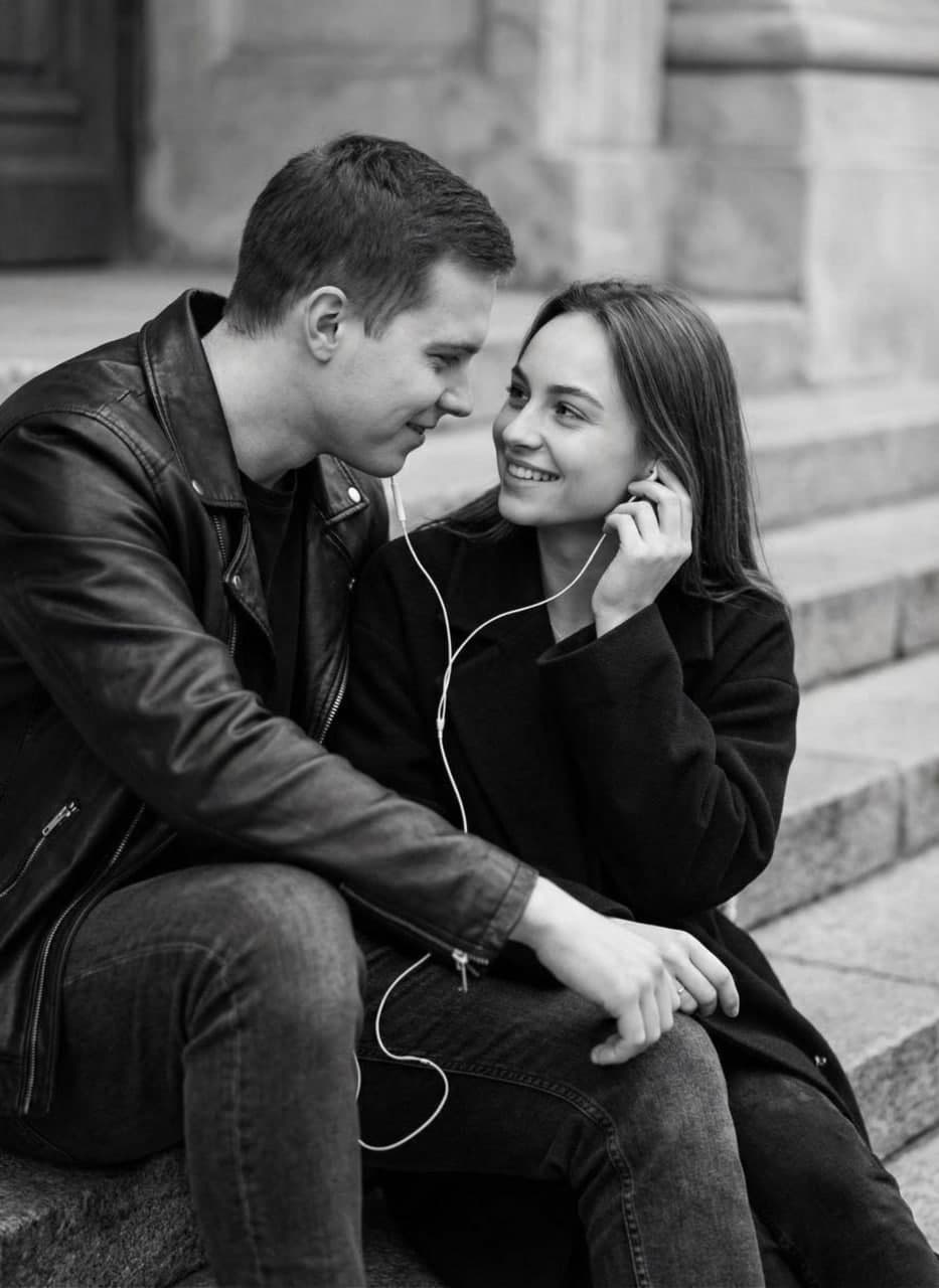 ИИ-фотосессия по фото: парень и девушка сидят на каменных ступенях и слушают музыку через одни наушники на улице